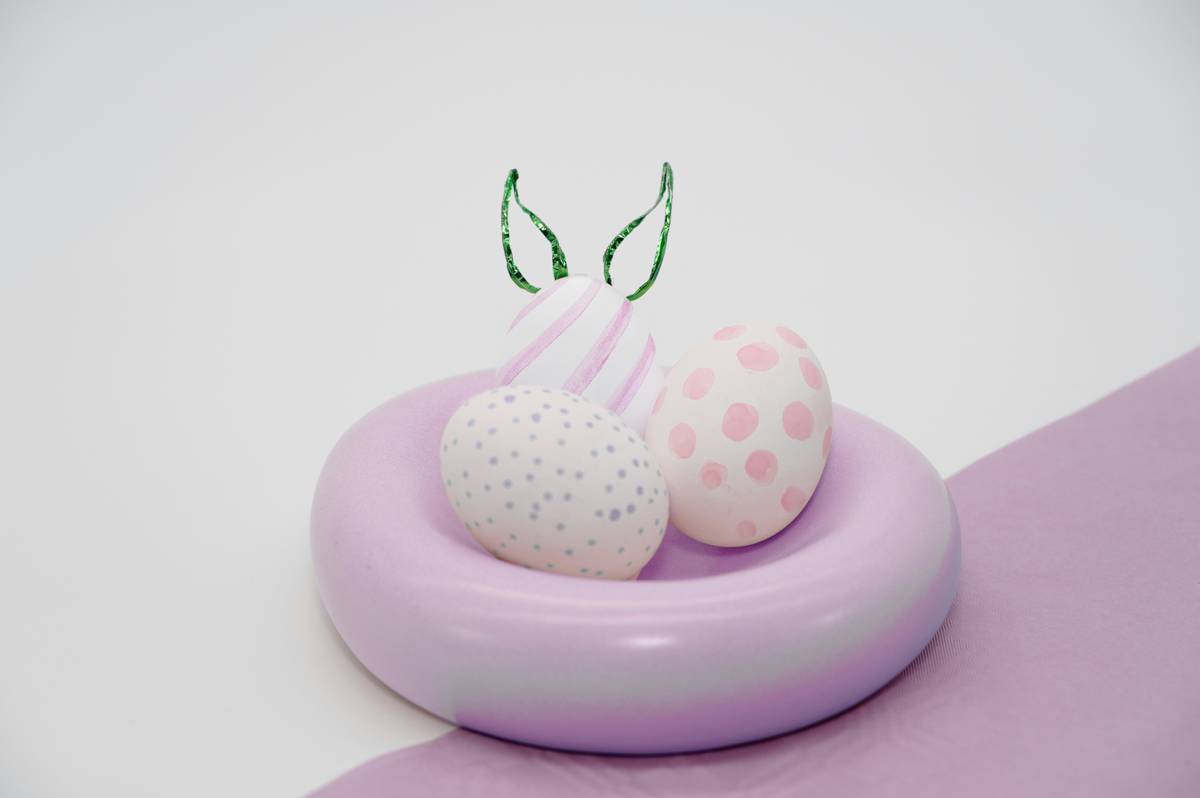 easter home decor pinterest with pastel eggs, linen napkins, and wooden tray on a farmhouse table